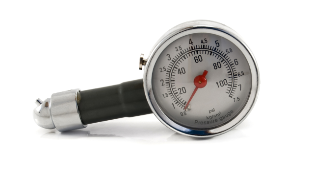 Close-up of a round pressure gauge showing measurements in psi and kg/cm² with a needle indicator.