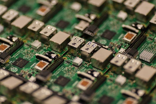 Close-up of a green printed circuit board with multiple USB ports and electronic components.