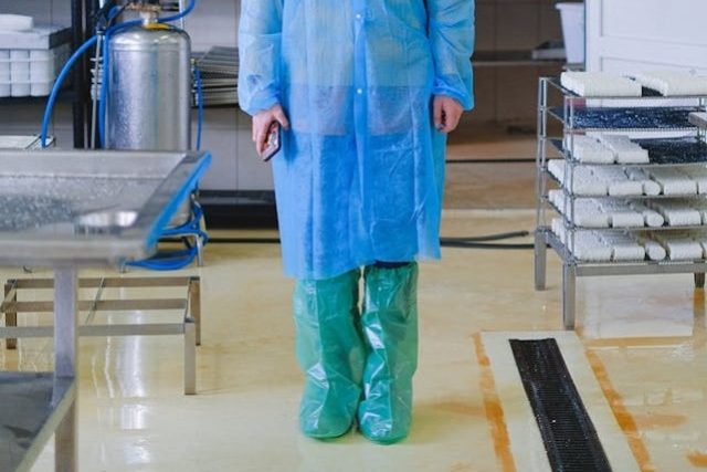 person-wearing-a-blue-dressing-gown-and-green-booties-to their-knees