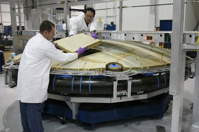 two-professionals-wearing-white-coats-building-something